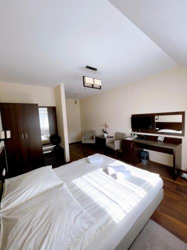 a large white bed in a room with a piano at Hotel Pod Chełmem in Ropa