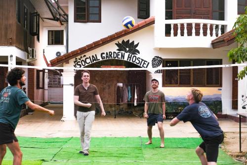 a group of people playing a game of volleyball at Social Garden Hostel in Chiang Rai