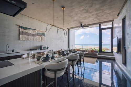 a kitchen with a bar with a view of the ocean at CELEVI Yomitan セレビィ 読谷 in Yomitan