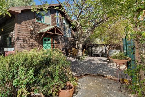 a house with a green door and a tree at THE HOUSE ROSH PINA - 3BRM WITH POOl in Rosh Pinna