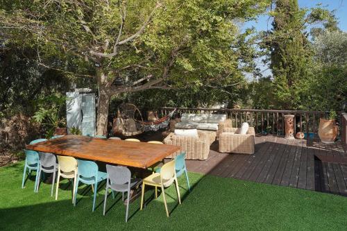 a wooden table and chairs in a yard at THE HOUSE ROSH PINA - 3BRM WITH POOl in Rosh Pinna