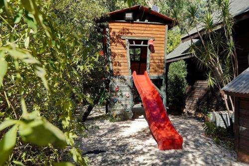 a red slide in front of a building at THE HOUSE ROSH PINA - 3BRM WITH POOl in Rosh Pinna