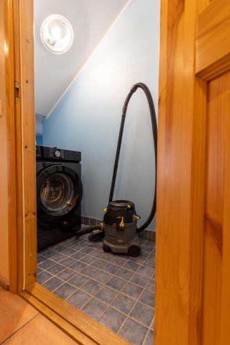 a vacuum in a room with a washing machine at Raja Lake House in Raja