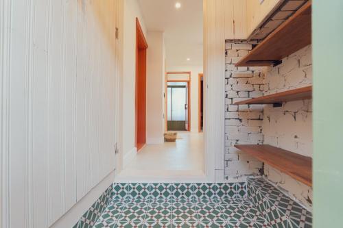 a hallway with a tile floor and a brick wall at Chun cheon Bongstay 2nd Floor in Chuncheon
