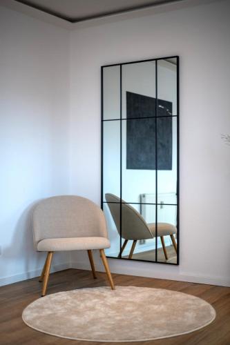 a chair in a room with a mirror at Comfortable 3 room apartment I 81 m2 I Central l Self-Check-In I Elevator & Balkony in Hannover