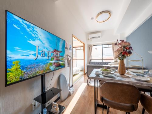 a living room with a large flat screen tv on a wall at Newly opened Hotel 3 京セラドーム徒歩10分 道頓堀 関西空港 大阪城 海遊館直行 USJ1回乗換 出張 Family friendly Free parking 15 minutes by car to USJ in Osaka