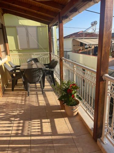a patio with a table and chairs on a balcony at Cedar House a Greek treasure in Sami