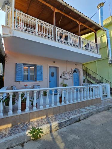 a house with a balcony with blue doors at Cedar House a Greek treasure in Sami