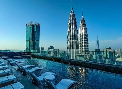 a pool on the roof of a building with tall buildings at Premier Suites Twin Towers at Star Residences in Kuala Lumpur