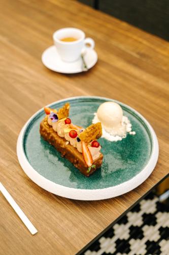 a plate of food on a table with a cup of coffee at Les Violettes Hotel & Spa in Jungholtz
