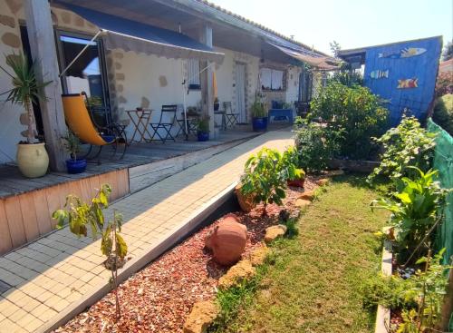 a garden in front of a house with plants at Les oliviers in LʼÎle-dʼOlonne