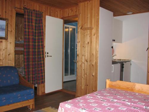 a bedroom with a bed and a chair and a window at Skjellbogen Hyttegrend in Sortland