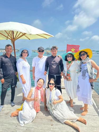 a group of people posing for a picture on the beach at Homestay Hoàng Phúc in Cu Lao Thu
