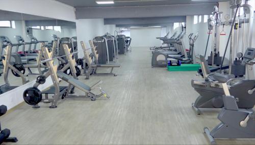 a gym with rows of treadms and cardio machines at Zepterme Spa&Wellness Luxury Apartments member of Zepter hotels in Vrnjačka Banja