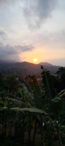 a sunset over a city with the sun in the distance at Casa Augusto Stunning view in Trindade