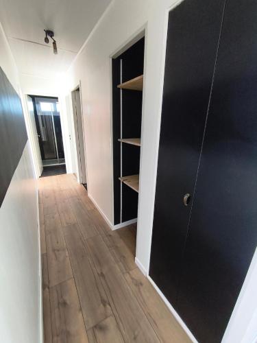 a hallway with black closet doors and a wooden floor at Gîte du Bois in Viry-Noureuil