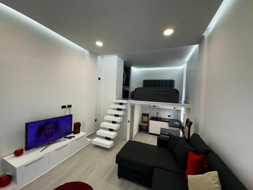 a living room with a black couch and a tv at Vila Calm in Pogradec