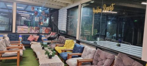 a room with lots of couches and tables and windows at Moon View Resort in Ein Kinya