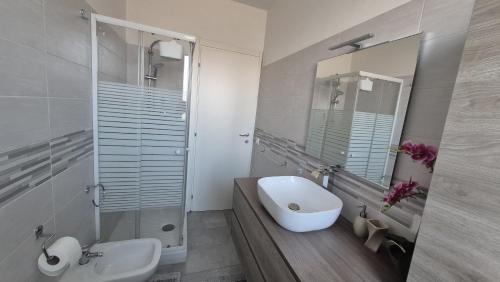 a white bathroom with a sink and a mirror at La dimora di Matteo in Marina di Montenero
