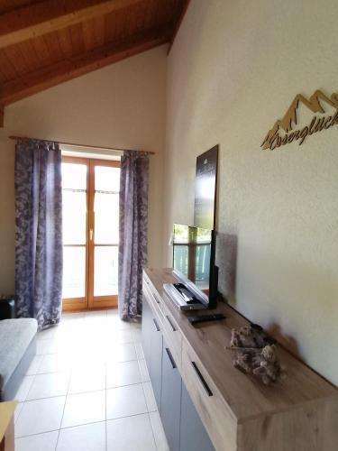 a living room with a television on a wooden counter at Ferienwohnung Osserglück in Lohberg