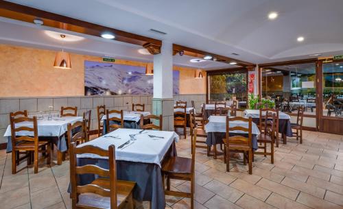 a dining room with tables and chairs in a restaurant at Hotel Rural Huerta del Laurel in Monachil