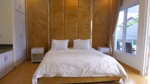 a bedroom with a large bed and a large window at Villa Dalia Puncak P2-12 in Cianjur