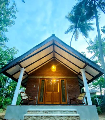 a house with a front porch with palm trees at Sigiriya Lahiru Homestay in Sigiriya