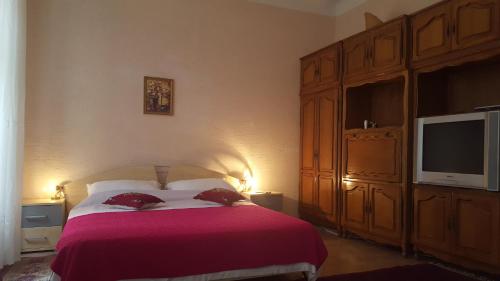 a bedroom with a large bed and a television at Apartment Aida in Rijeka