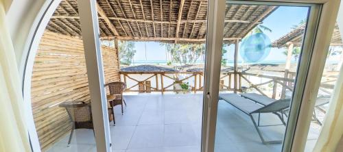 a room with a balcony with a view of the ocean at Royal Mandarin Hotel & Resort in Pwani Mchangani