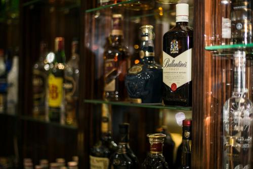 a shelf full of bottles of alcohol in a bar at Azalea Hotel Baku in Baku