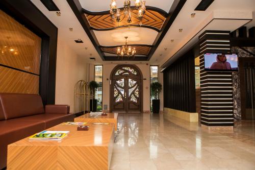 vestíbulo con sofá, escalera y puerta en Azalea Hotel Baku, en Baku