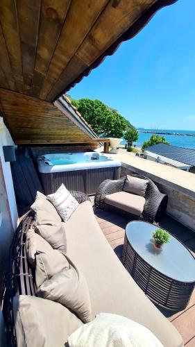 a patio with a couch and a table and a hot tub at Villa Bellavista in Kavarna