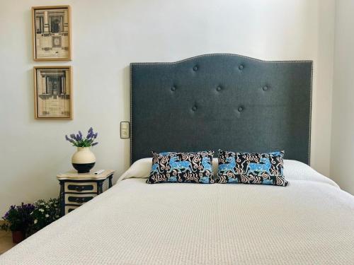 a bed with a large headboard in a bedroom at La Casa de Claudio Marcelo in Córdoba
