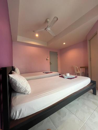 two beds in a room with pink walls at Bonita House in Bangkok