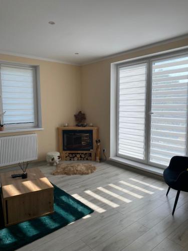 a living room with two large windows and a couch at Apartament Koszarawa in Koszarawa