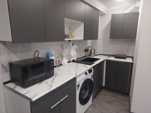 a small kitchen with a microwave and a washer at Komfort Ilona in Yerevan