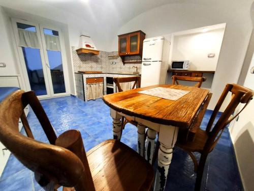 a kitchen with a wooden table and some chairs at Ely House Costa d'Amalfi Casa Vacanze in Albori