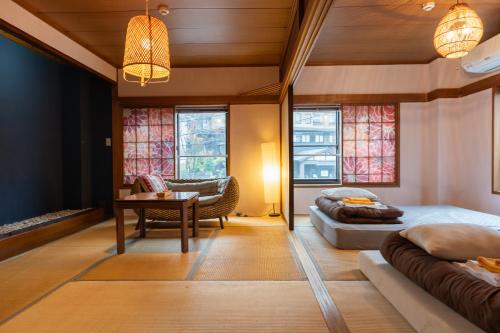 a bedroom with two beds and a table and a chair at Kaido Yuzawa Onsen Hostel in Yuzawa