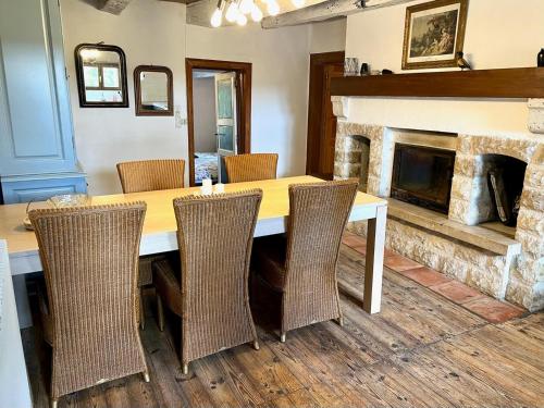 a dining room with a table and chairs and a fireplace at Gîte La Vésarnie in Montaigu-de-Quercy