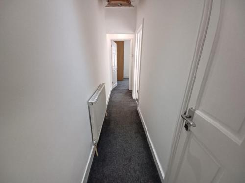 an empty hallway with a white door and a hallway at The Maple in Grays Thurrock