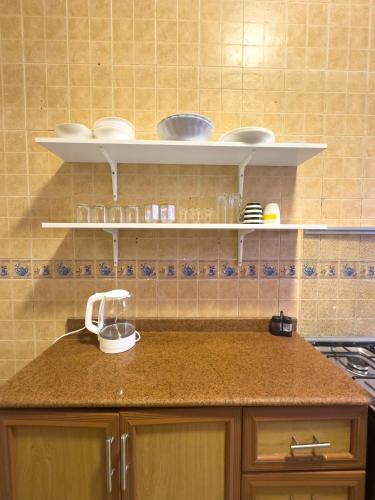 a kitchen counter with plates and bowls on shelves at Qaitbay Citadel View in Alexandria