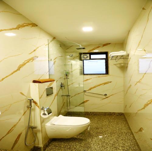 a bathroom with a toilet and a shower at The Pavillion 2 Nr City Centre II in kolkata