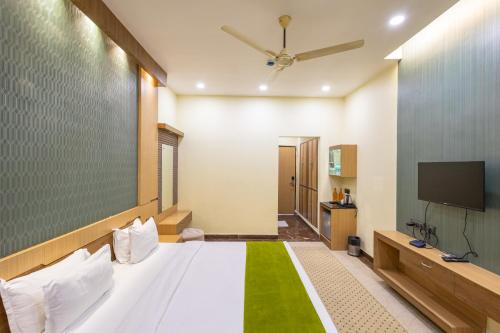 a bedroom with a white bed and a flat screen tv at BUDDHA HERITAGE RESORT in Bodh Gaya