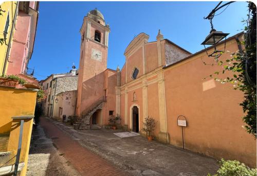a church with a clock tower in a street at Emozione Blu in Monte Marcello