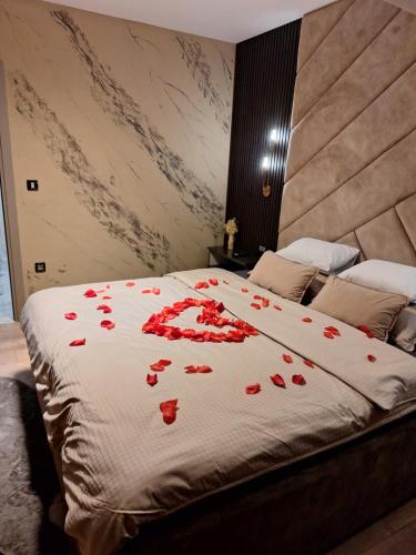 a bed with red rose petals on it at Mery 2 in Slavonski Brod