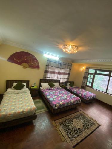 a room with three beds and a chandelier at Eco Resort in Dhulikhel