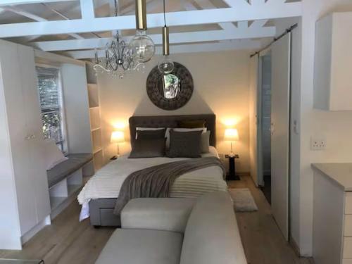 a bedroom with a bed and a couch and a chandelier at African Diamond - Date Night Suite in Benoni