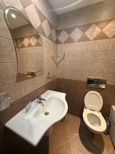 ein Badezimmer mit einem weißen Waschbecken und einer Toilette in der Unterkunft Prime location one bed apartment with hydro bath in Royal Plaza in Borowez