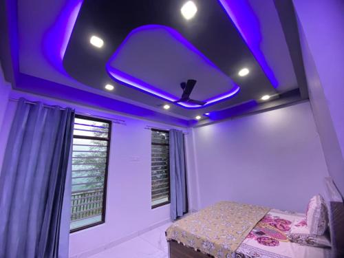 a bedroom with a purple ceiling with a bed and a window at Revanta Home Stay in Anandpur Sāhib