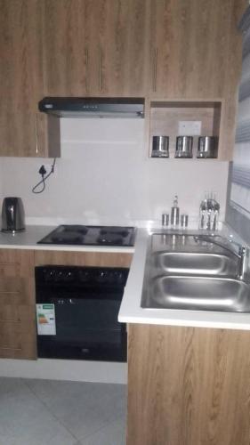 a kitchen with a sink and a stove at Kasane Boutique House in Kasane